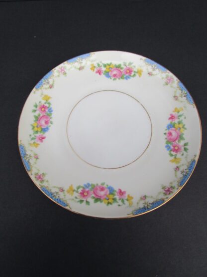 White floral saucer with gold trim.