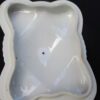 A white plastic container with a hole in it.
