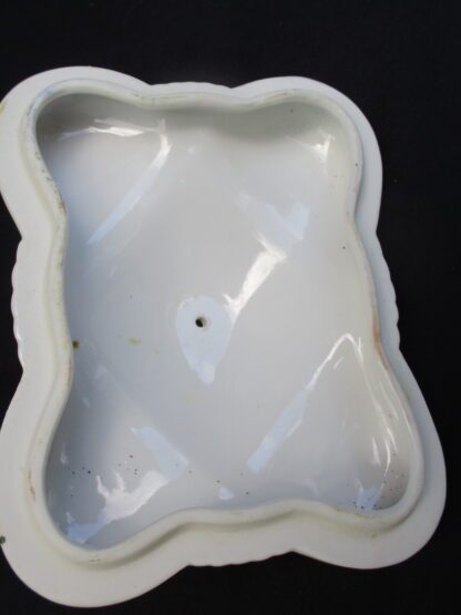 A white plastic container with a hole in it.