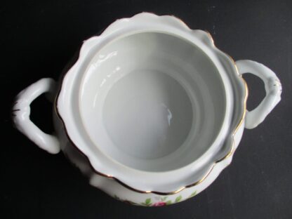 A white bowl with two handles on the bottom.