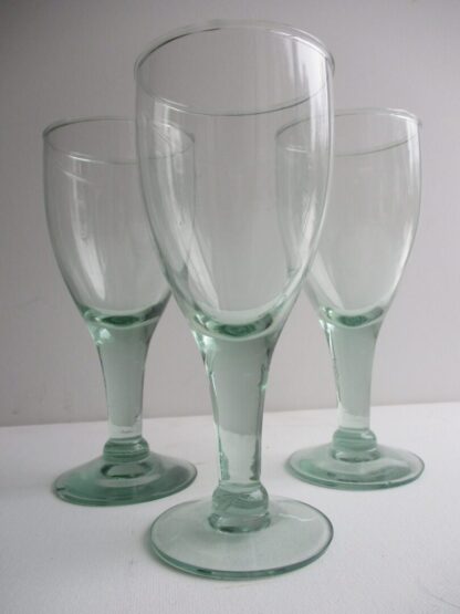 Three glasses are sitting on a table.