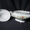 A white bowl with flowers on it and a black background