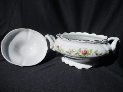A white bowl with flowers on it and a black background
