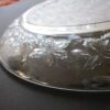 A silver plate with leaves on it
